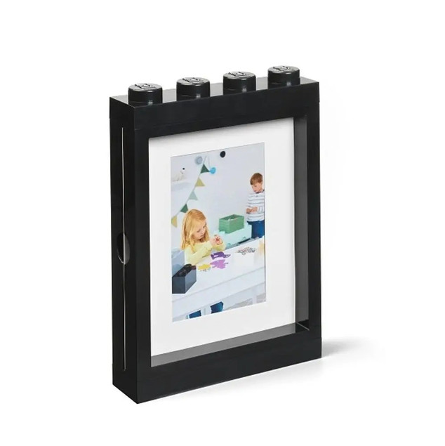 E2001A;">oryginalną ramką na zdjęcia LEGO®</strong> w eleganckim, czarnym kolorze! Ta stylowa ramka o wymiarach zewnętrznych 19 x 27 cm to nie tylko praktyczny element wystroju, ale prawdziwa gratka dla każdego miłośnika klocków LEGO. Idealnie wpisze się